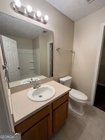 a bathroom with a sink a toilet a mirror and shower