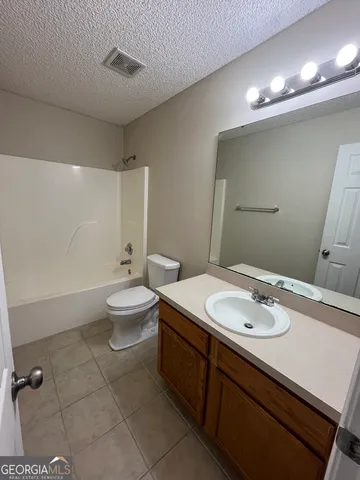 a bathroom with a double vanity sink toilet and mirror