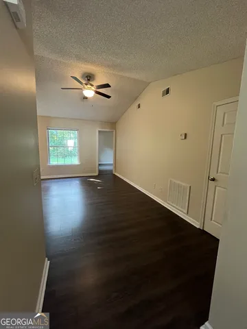 an empty room with wooden floor and window