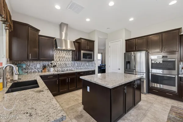 a kitchen with granite countertop kitchen island a sink dining table and chairs