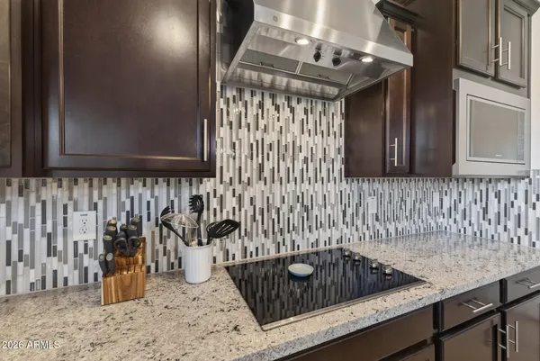 a kitchen with stainless steel appliances kitchen island granite countertop a stove a refrigerator a sink a stove a dining table and chairs