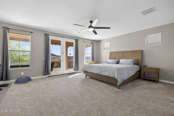 a bedroom with a bed couch and large window