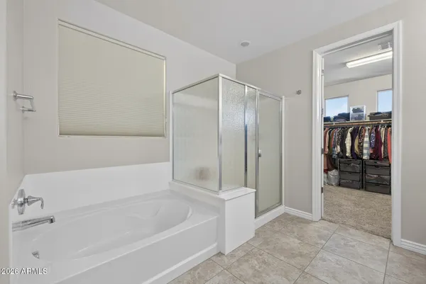 a spacious en suite bathroom with a tub double vanity and mirrors