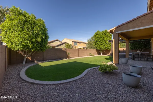 a view of a patio with table and chairs potted plants and floor to ceiling window