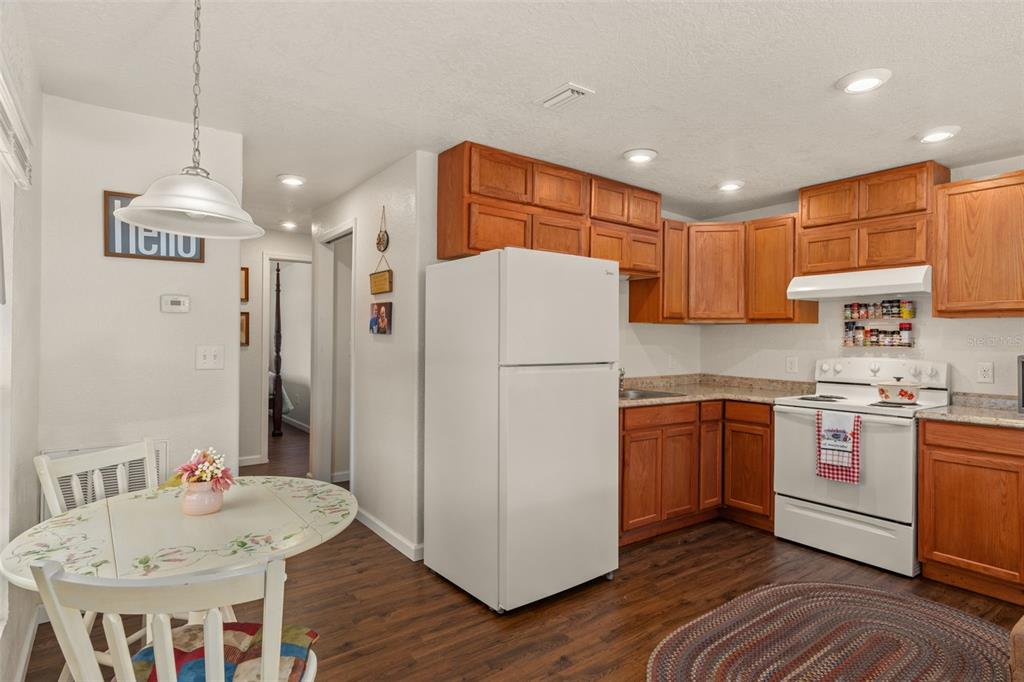 6287 North Crew Terrace Hernando, FL 34442 - Photo 18 of 38 a kitchen with stainless steel appliances granite countertop a refrigerator a sink dishwasher a stove a dining table and chairs with wooden floor