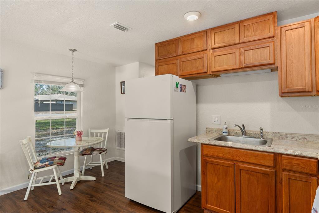 6287 North Crew Terrace Hernando, FL 34442 - Photo 19 of 38 a white kitchen with a refrigerator a stove a sink and cabinetry