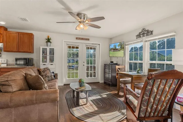 a living room with furniture a flat screen tv and large window