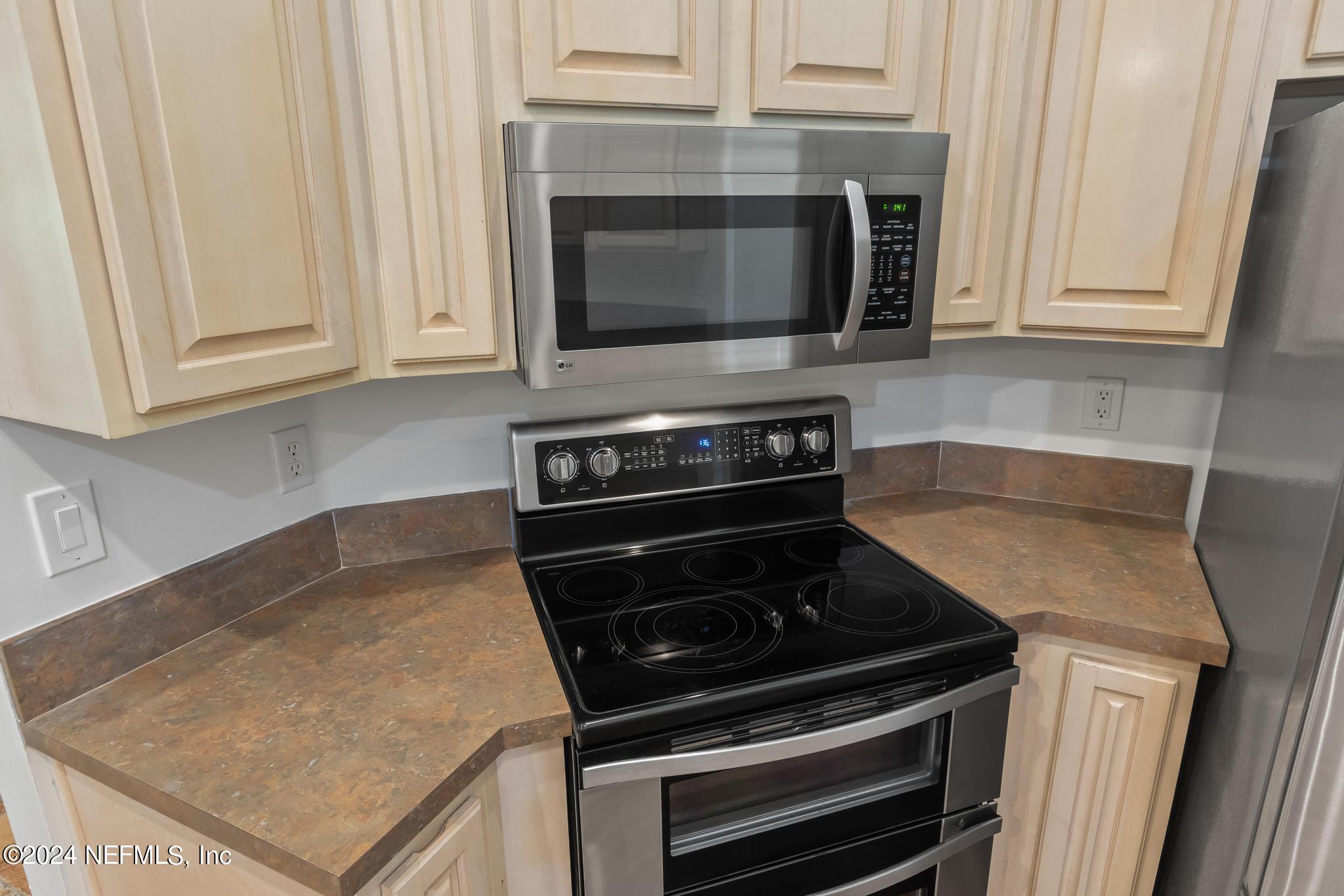 2949 Turning Leaf Lane Jacksonville, FL 32221 - Photo 44 of 116 a kitchen with granite countertop a stove and a microwave