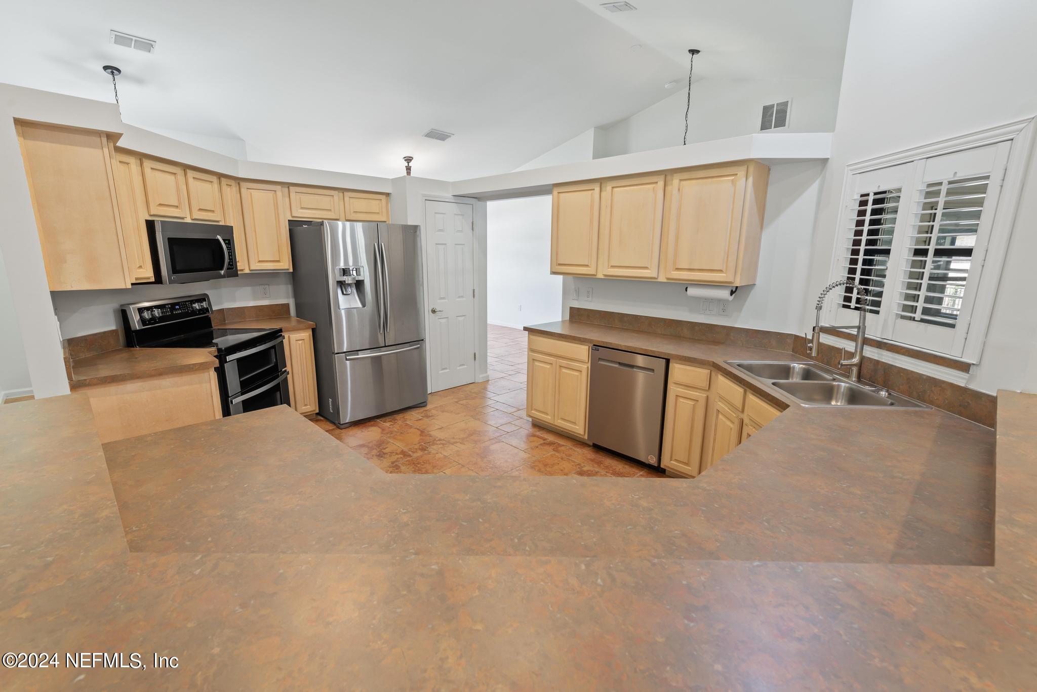 2949 Turning Leaf Lane Jacksonville, FL 32221 - Photo 46 of 116 a large kitchen with stainless steel appliances granite countertop a large counter top stainless steel appliances a stove a refrigerator a sink a window and white cabinets