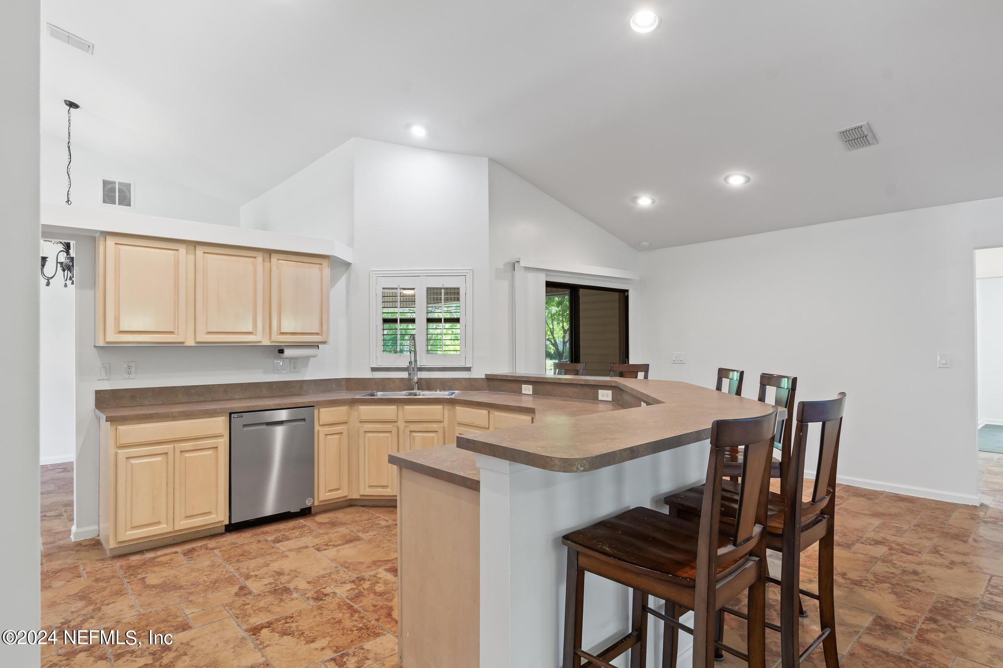 2949 Turning Leaf Lane Jacksonville, FL 32221 - Photo 47 of 116 a kitchen with stainless steel appliances granite countertop table chairs sink and cabinets