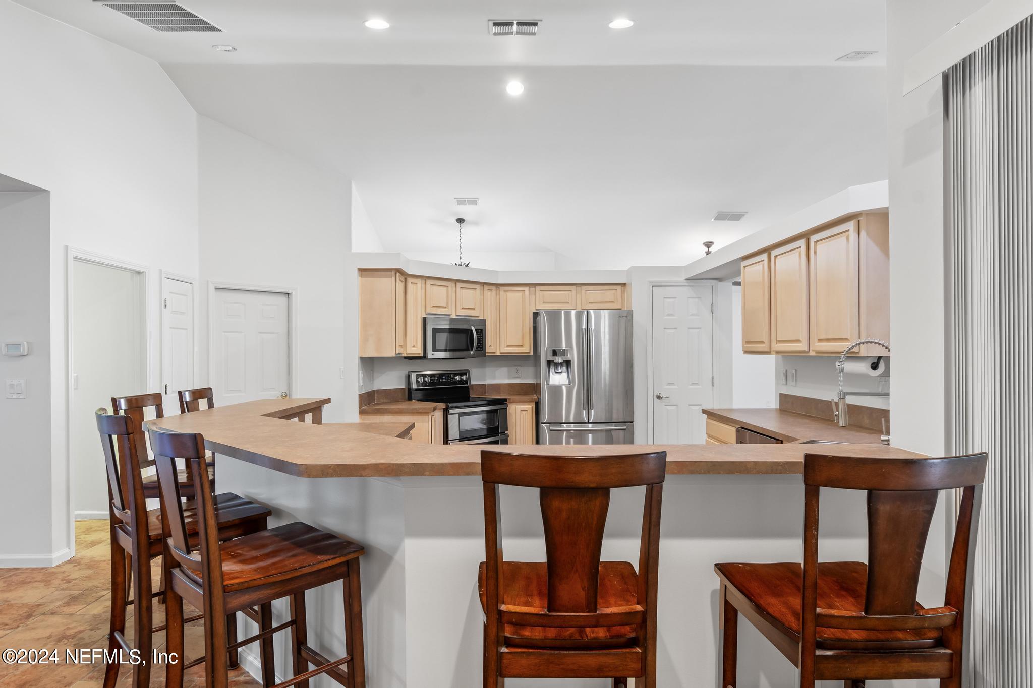 2949 Turning Leaf Lane Jacksonville, FL 32221 - Photo 48 of 116 a dining room with stainless steel appliances kitchen island granite countertop a dining table and chairs