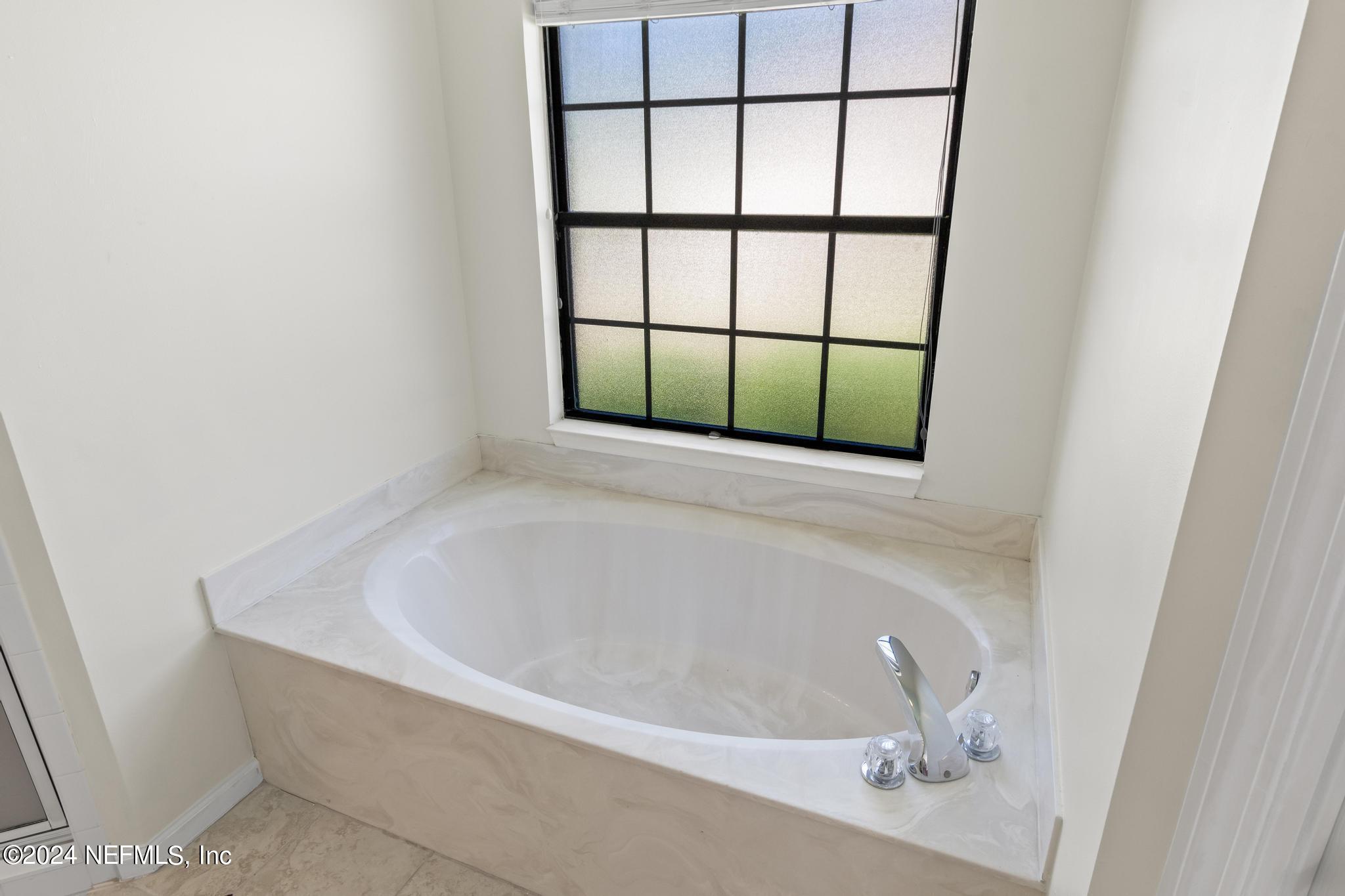 2949 Turning Leaf Lane Jacksonville, FL 32221 - Photo 70 of 116 a white bath tub sitting next to a window