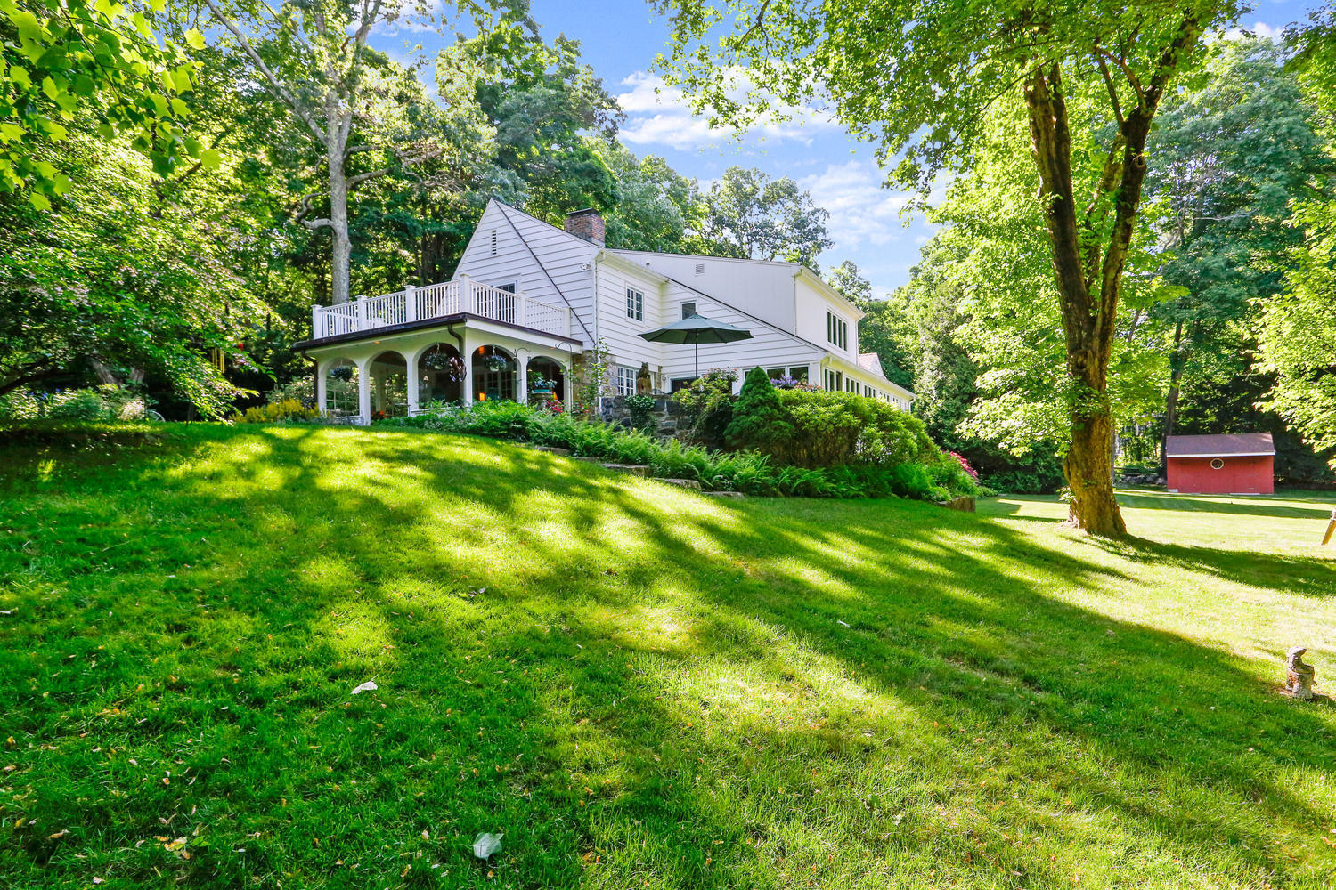 573 Valley Road New Canaan, CT 06840 - Photo 1 of 53 a front view of a house with garden