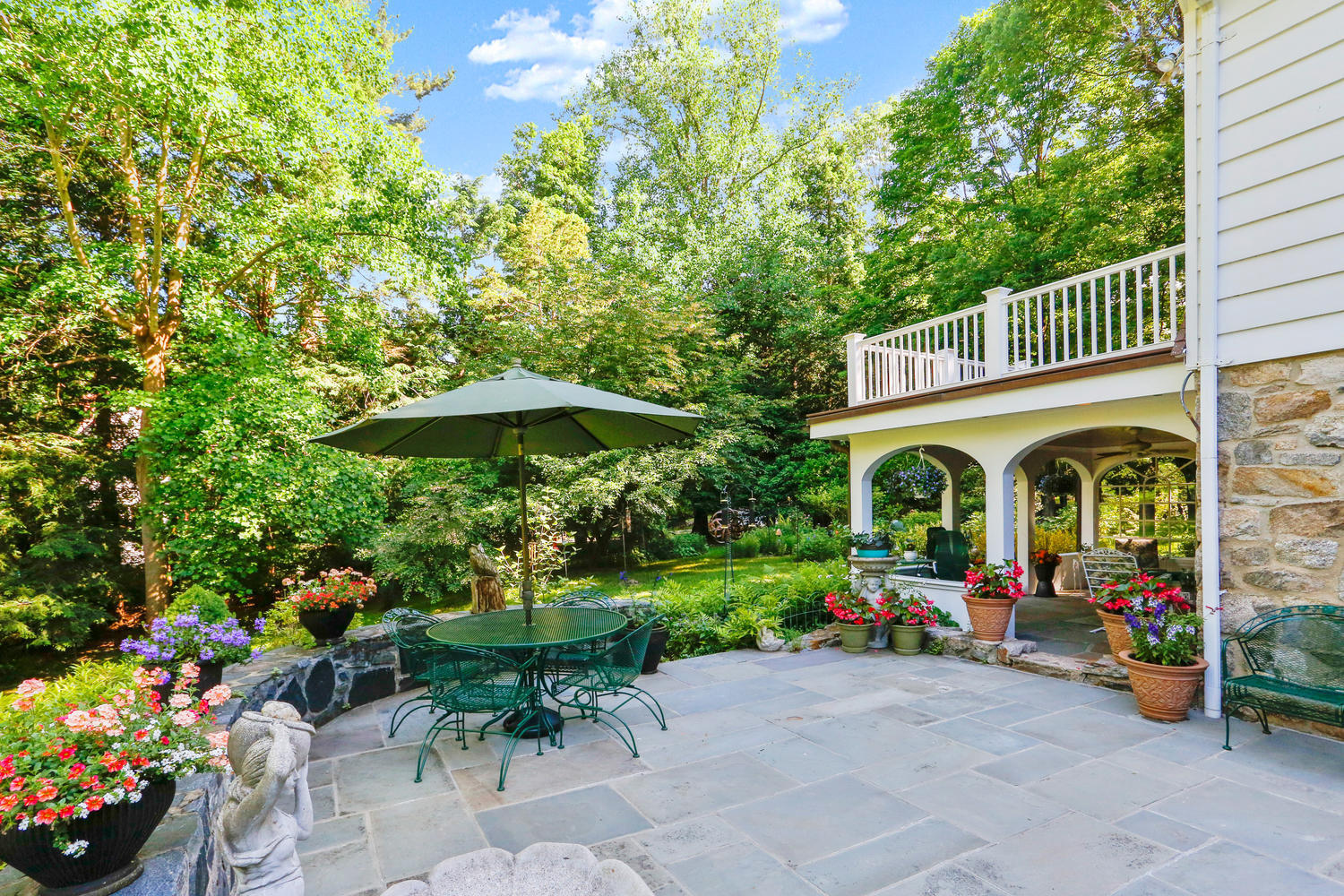 573 Valley Road New Canaan, CT 06840 - Photo 33 of 53 a front view of a house with a yard table and chairs