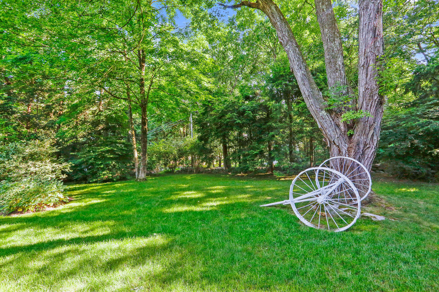 573 Valley Road New Canaan, CT 06840 - Photo 36 of 53 a view of a backyard with table and chairs and a tree