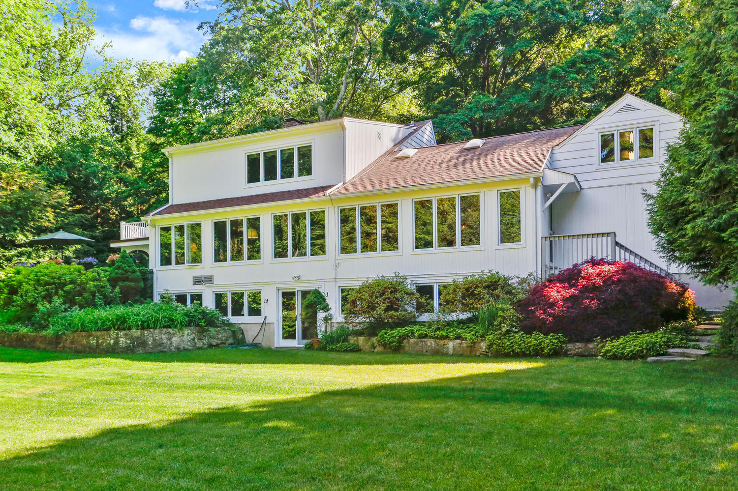 573 Valley Road New Canaan, CT 06840 - Photo 37 of 53 a front view of a house with a garden