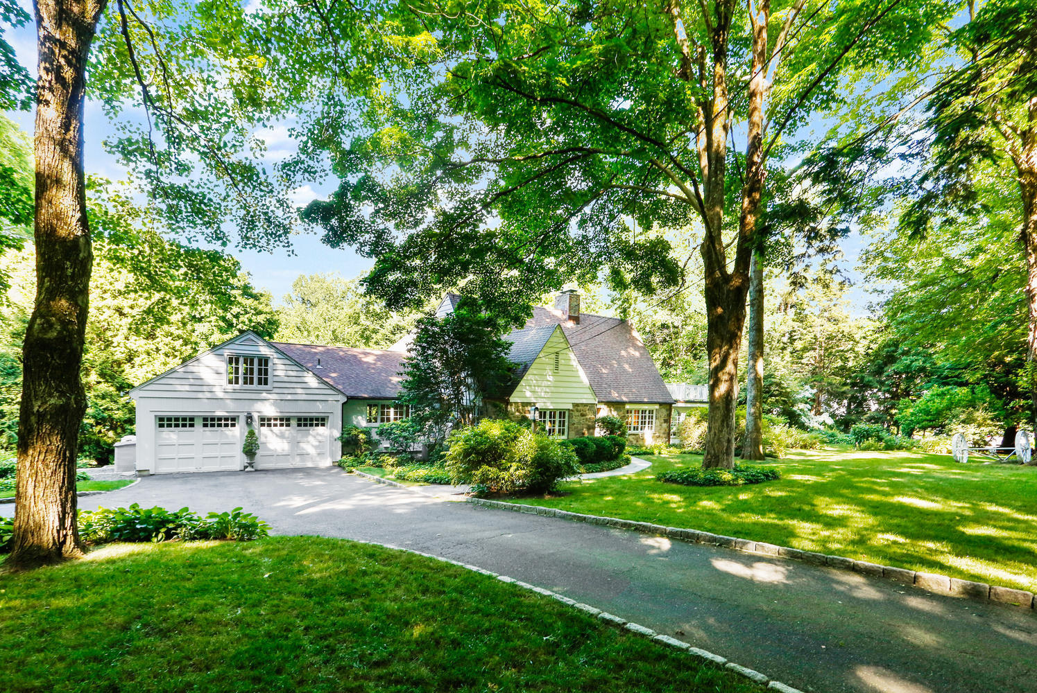 573 Valley Road New Canaan, CT 06840 - Photo 43 of 53 a front view of a house with a garden and trees