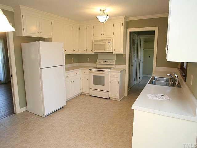 11808 Coachmans Way Raleigh, NC 27614 - Photo 4 of 12 a kitchen with a refrigerator sink stove and cabinets