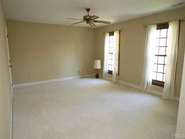 11808 Coachmans Way Raleigh, NC 27614 - Photo 6 of 12 an empty room with windows and a ceiling fan