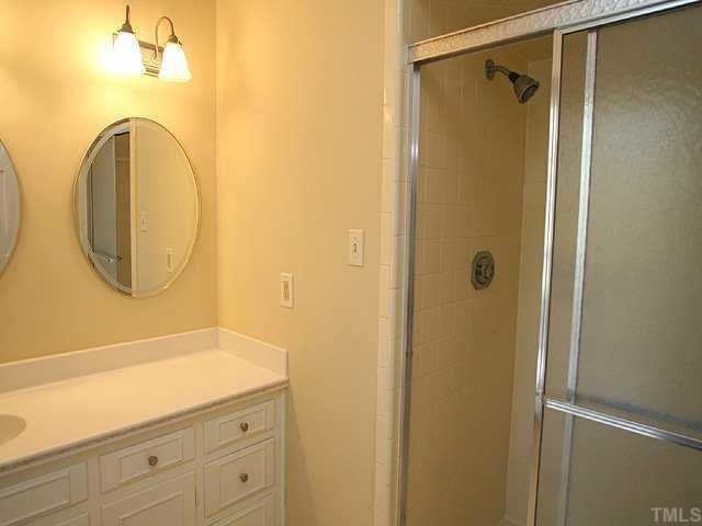 11808 Coachmans Way Raleigh, NC 27614 - Photo 7 of 12 a bathroom with a shower a mirror and a sink