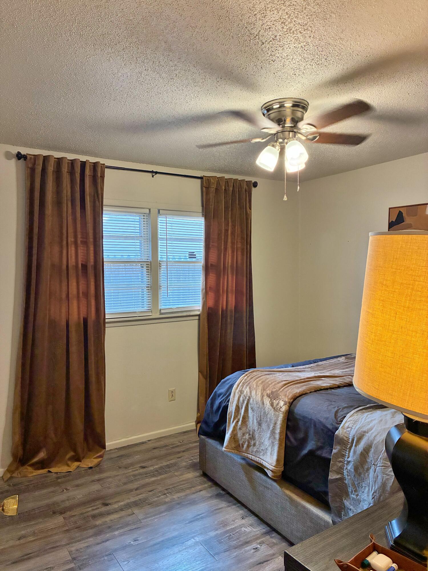 4203 17th Street Lubbock, TX 79416 - Photo 12 of 15 a bedroom with a bed and wooden floor