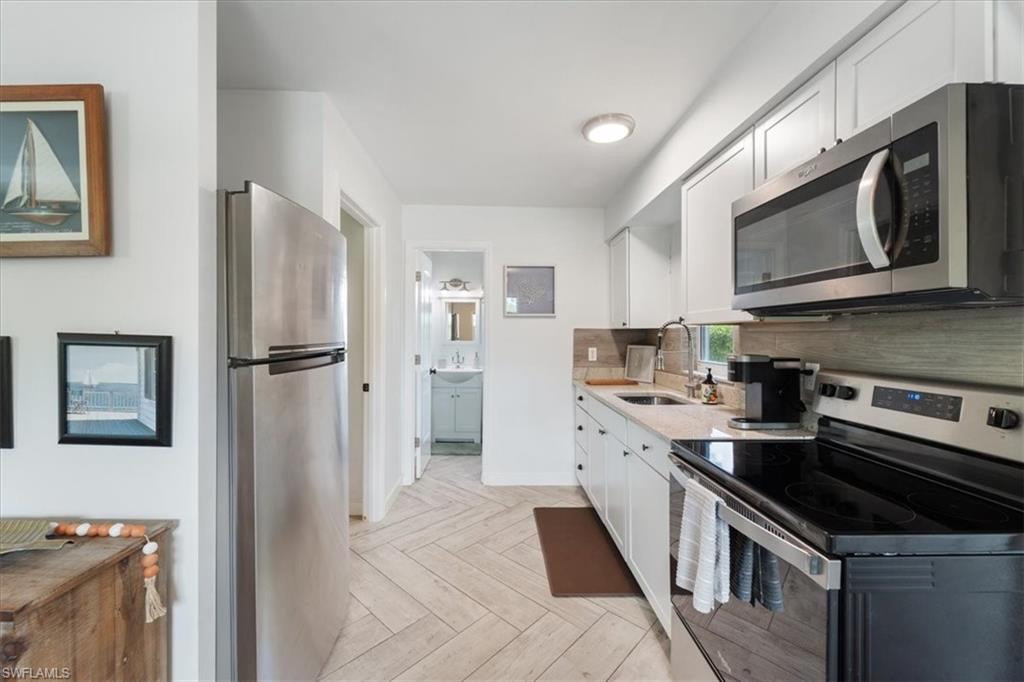 3365-3367 Estey Avenue Naples, FL 34104 - Photo 20 of 30 a kitchen with stainless steel appliances a stove microwave and a refrigerator