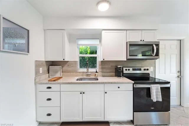 a kitchen with a sink stove and microwave