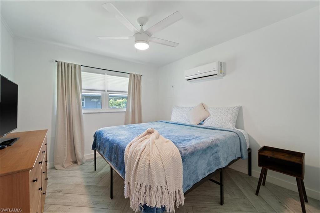 3365-3367 Estey Avenue Naples, FL 34104 - Photo 23 of 30 a bedroom with a bed and a flat screen tv