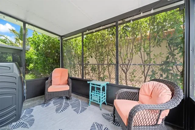 a living room with a chair and large windows