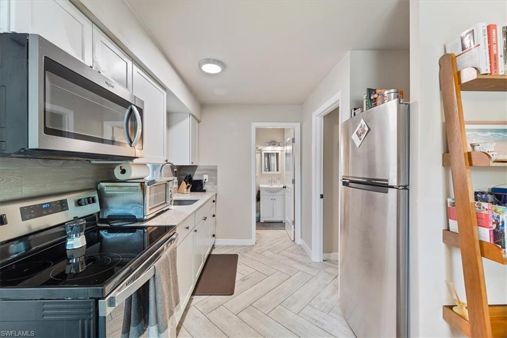 3365-3367 Estey Avenue Naples, FL 34104 - Photo 7 of 30 a kitchen with granite countertop a refrigerator stove and sink