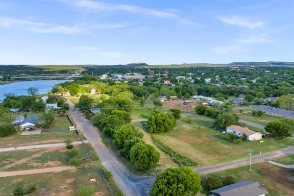 an aerial view of residential houses with outdoor space and trees