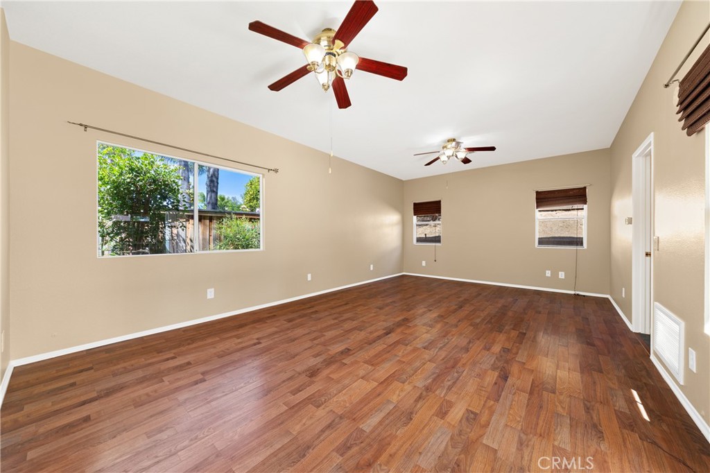 22678 Weatherly Court Wildomar, CA 92595 - Photo 18 of 54 Spacious Downstairs Primary Bedroom With Ceiling Fan And Wood-Look Flooring