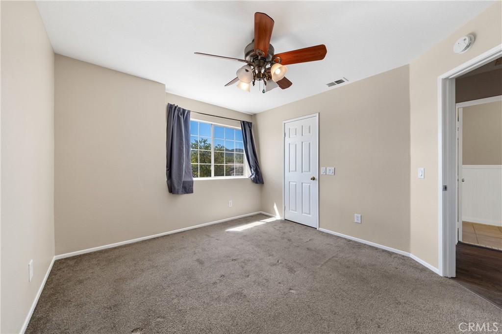 22678 Weatherly Court Wildomar, CA 92595 - Photo 42 of 54 Upstairs Bedroom With Ceiling Fan, Natural Light, And Neutral Finishes