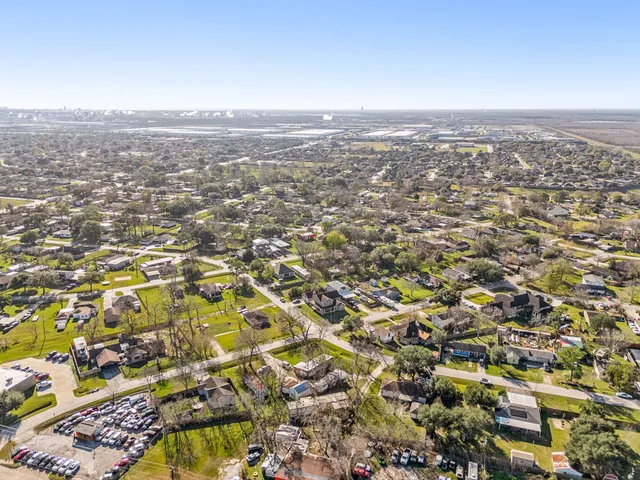 a front view of a house with garden and trees