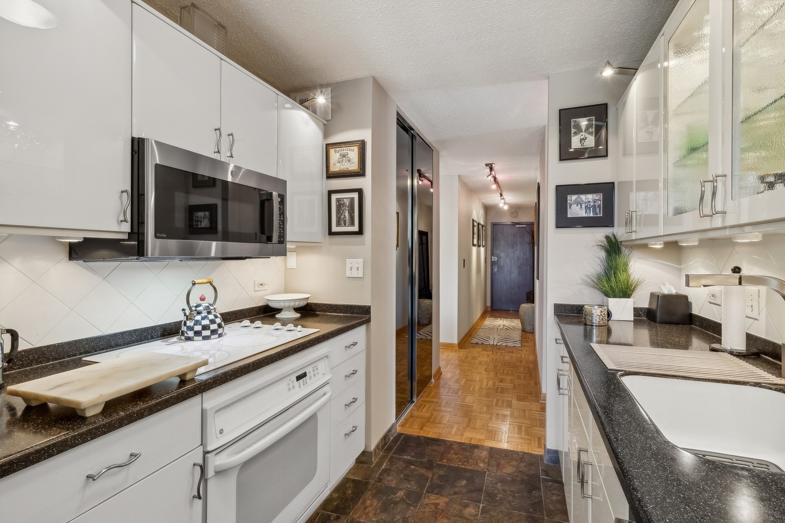71 East Division Street, Unit 906 Chicago, IL 60611 - Photo 8 of 20 a kitchen with stainless steel appliances granite countertop a sink stove and refrigerator