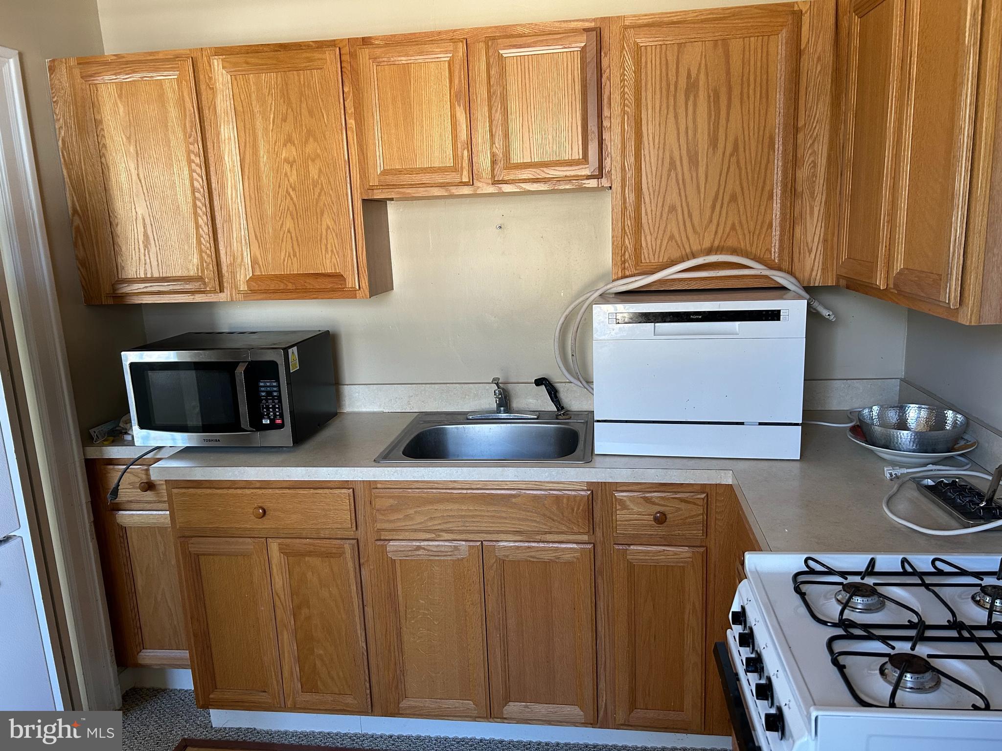 265 Moore Street, Unit 2 Princeton, NJ 08540 - Photo 3 of 7 a kitchen with stainless steel appliances wooden cabinets and a stove top oven