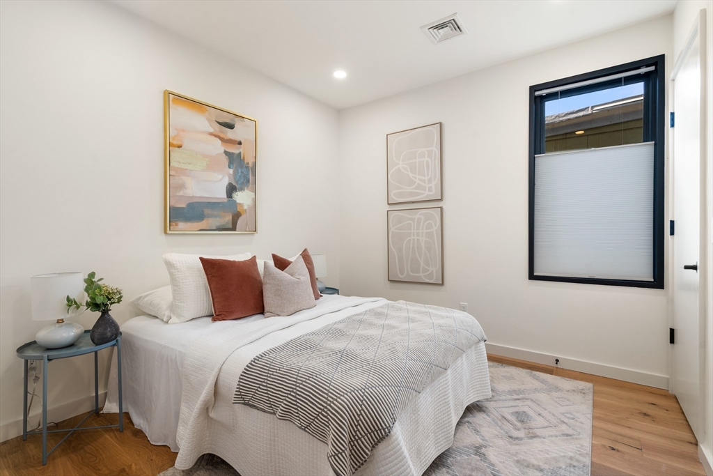 191 Condor Street, Unit 6 Boston, MA 02128 - Photo 10 of 14 a bedroom with a bed and a painting on the wall