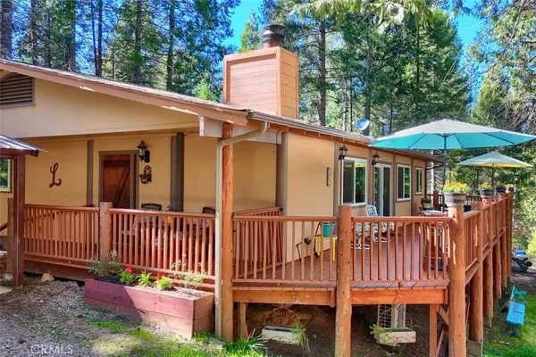 a view of a house with a deck and furniture