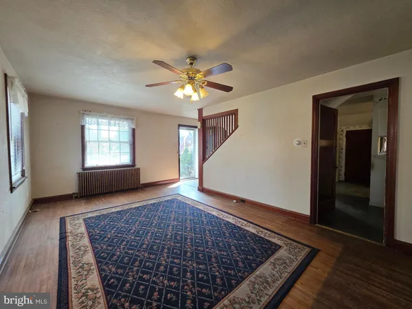 an empty room with windows and ceiling fan