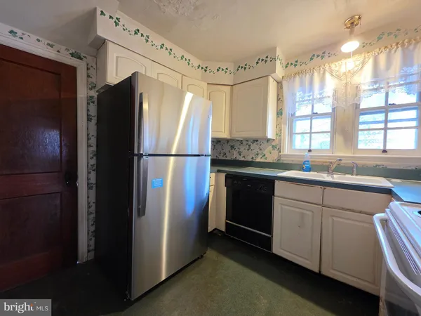 a kitchen with stainless steel appliances a refrigerator sink and cabinets