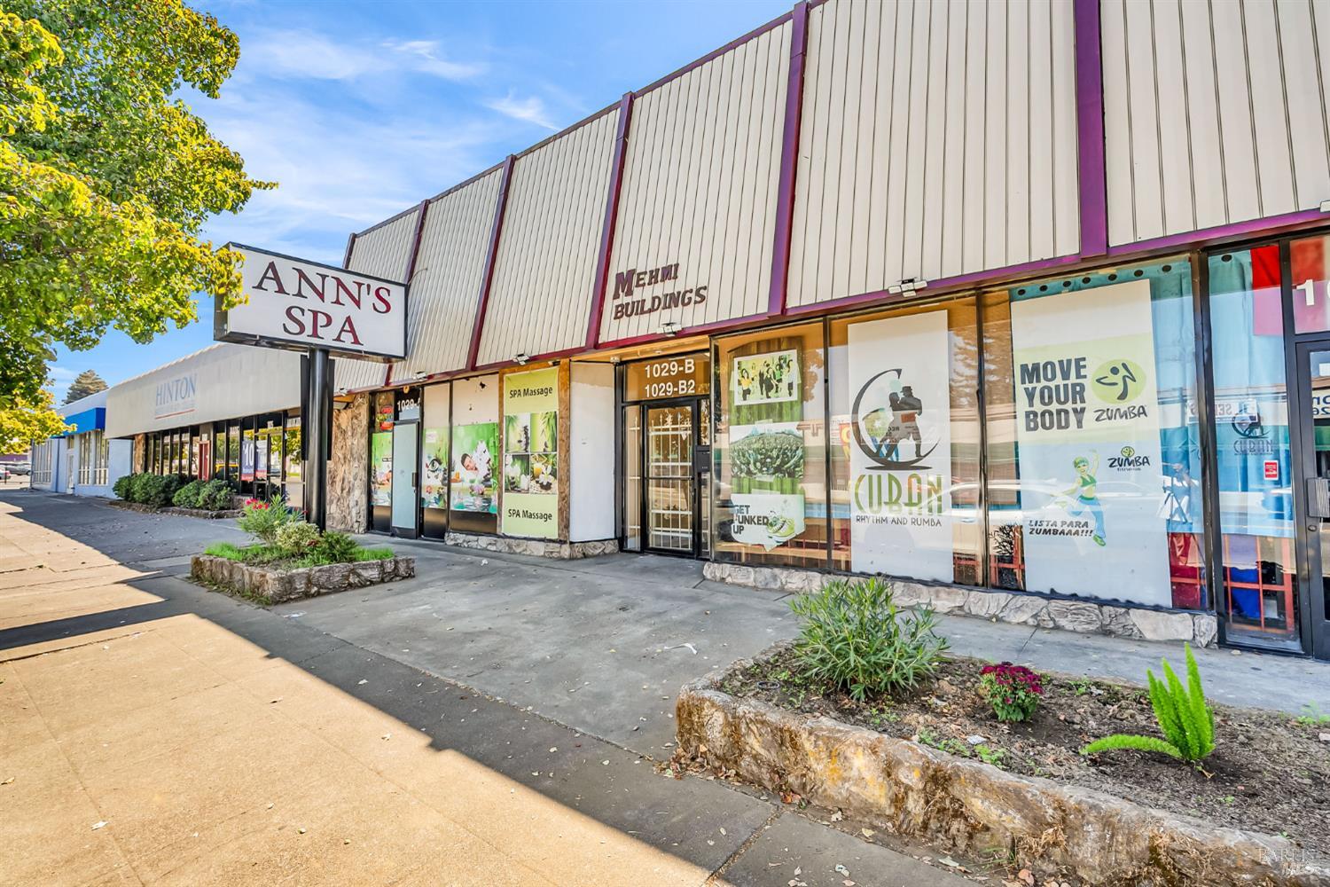 a front view of a building with a garden