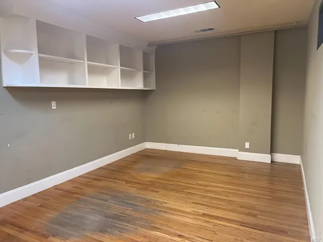 a view of an empty room with wooden floor