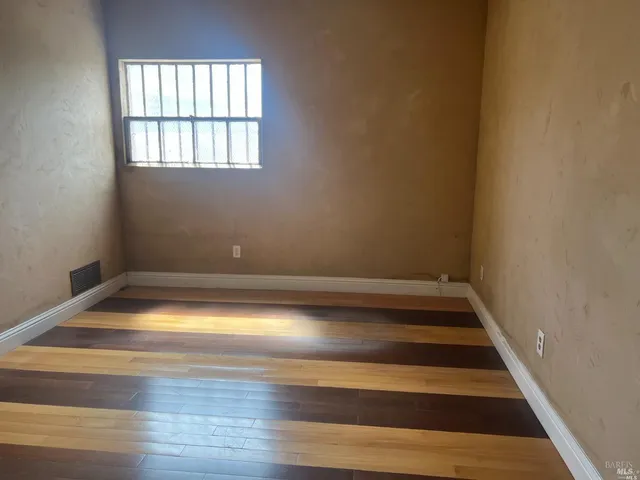 a view of a room with wooden floor and window