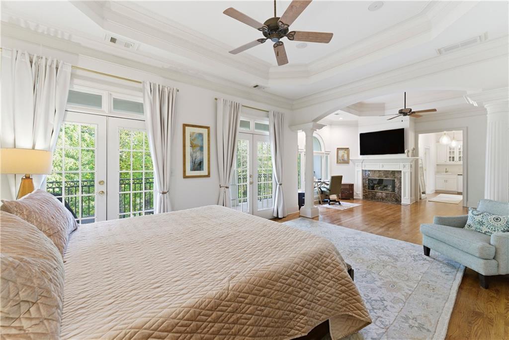 2918 Major Ridge Trail Duluth, GA 30097 - Photo 40 of 70 a spacious bedroom with a large bed a flat screen tv and a fireplace