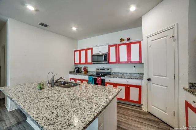 a kitchen with stainless steel appliances granite countertop a sink stove and cabinets