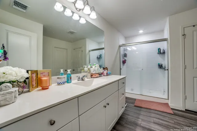 a bathroom with a sink mirror and shower
