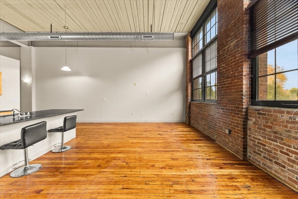 685 Social Street, Unit 215 Woonsocket, RI 02895 - Photo 21 of 40 a view of a room with wooden floor and furniture