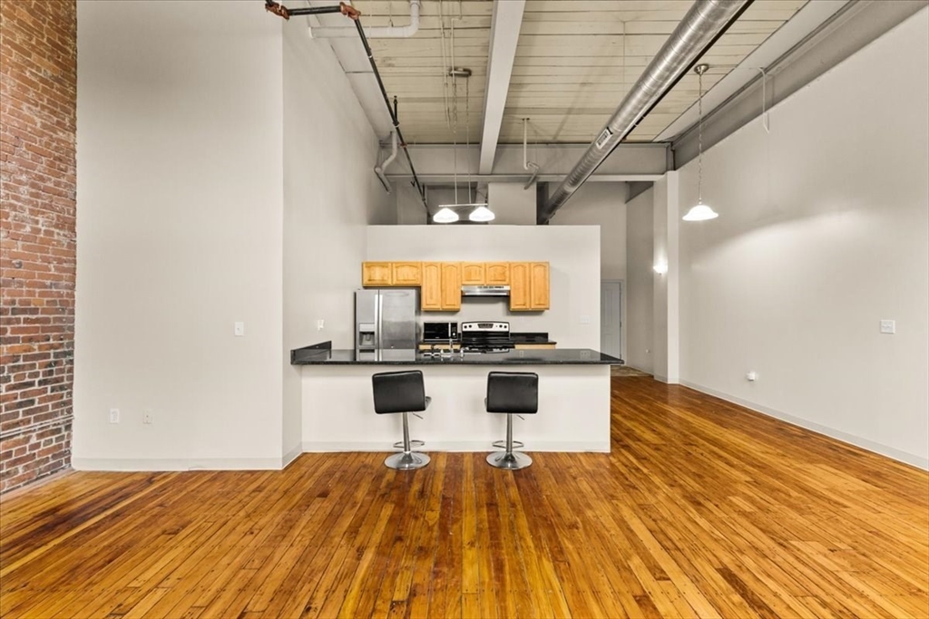 685 Social Street, Unit 215 Woonsocket, RI 02895 - Photo 32 of 40 a view of kitchen with a sink and dishwasher with wooden floor