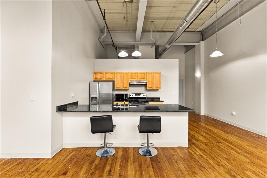685 Social Street, Unit 215 Woonsocket, RI 02895 - Photo 35 of 40 a kitchen with a sink cabinets and wooden floor