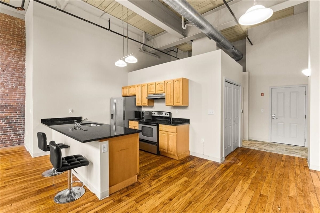 685 Social Street, Unit 215 Woonsocket, RI 02895 - Photo 36 of 40 a kitchen with a stove a refrigerator and a stove